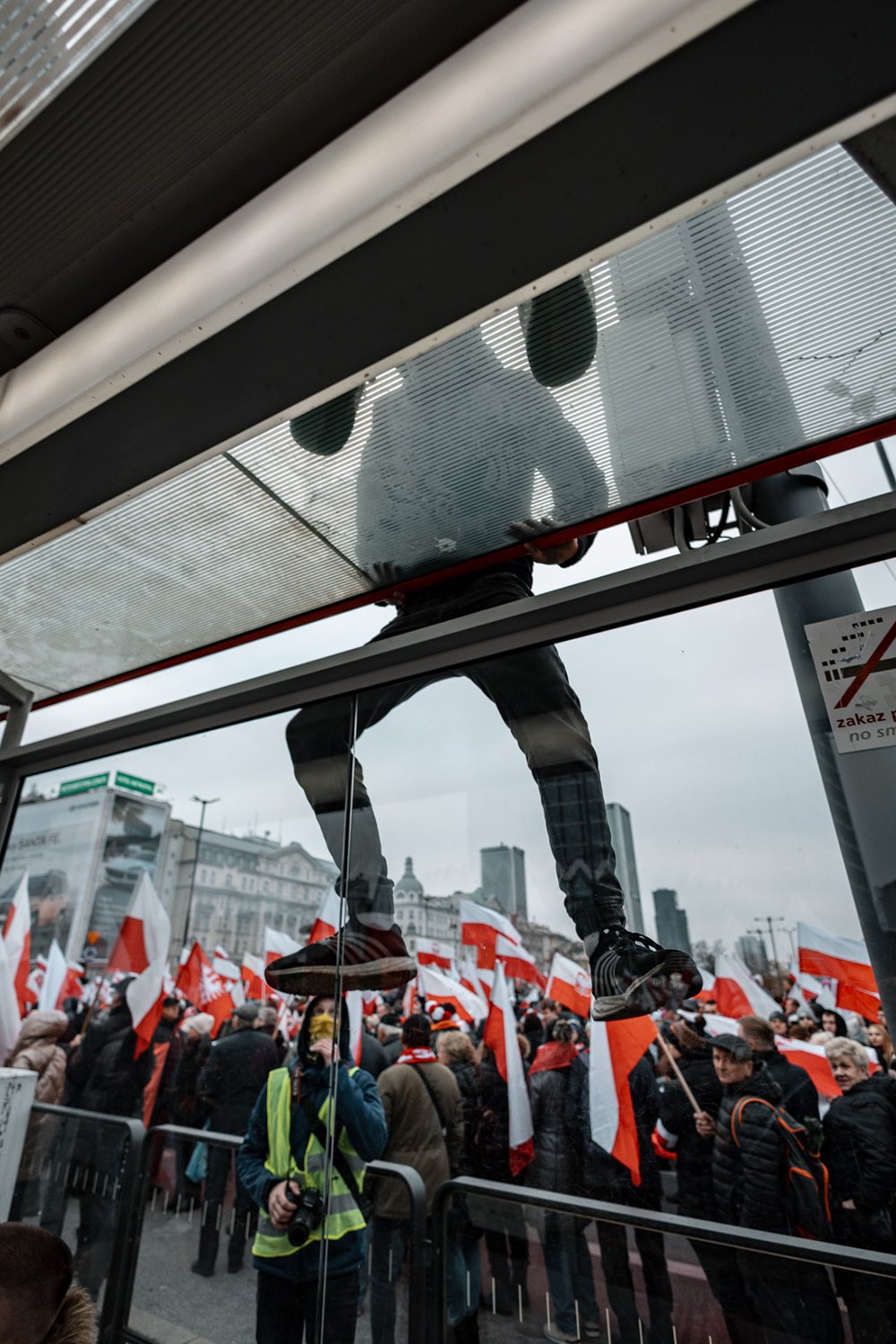 Demonstrator climbing onto a bus shelter