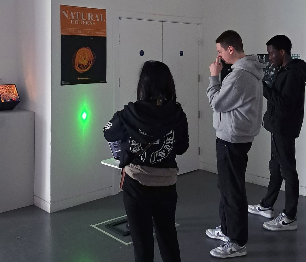 Exhibition view showing students looking at interactive installation.