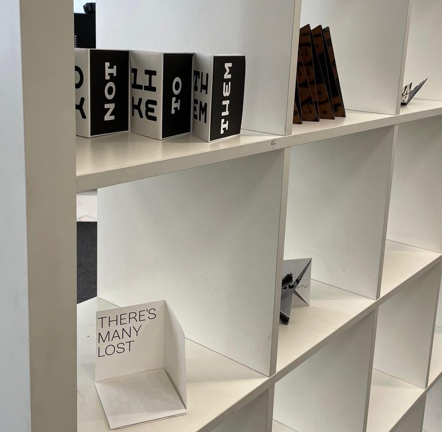 Exhibition view showing publications on shelves.