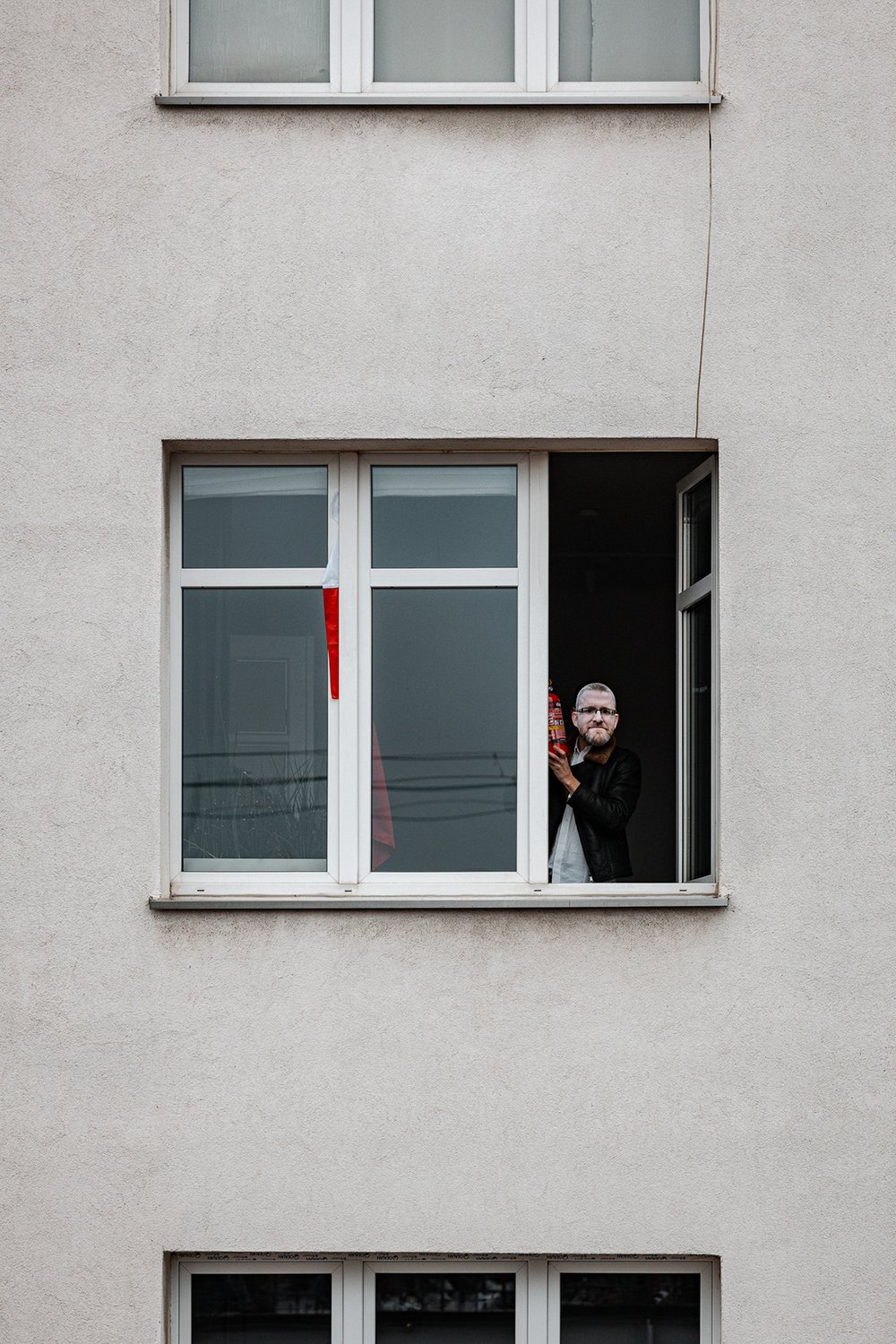 Man watching the demonstration from an apartment window