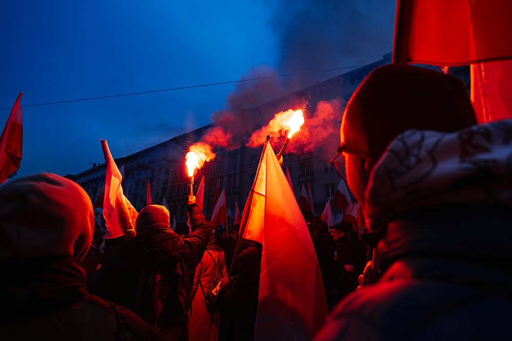 Group of demonstrators at night holding flags and flaming torches