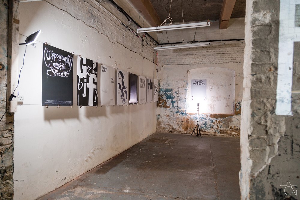 Typographic posters hung on rough brick walls